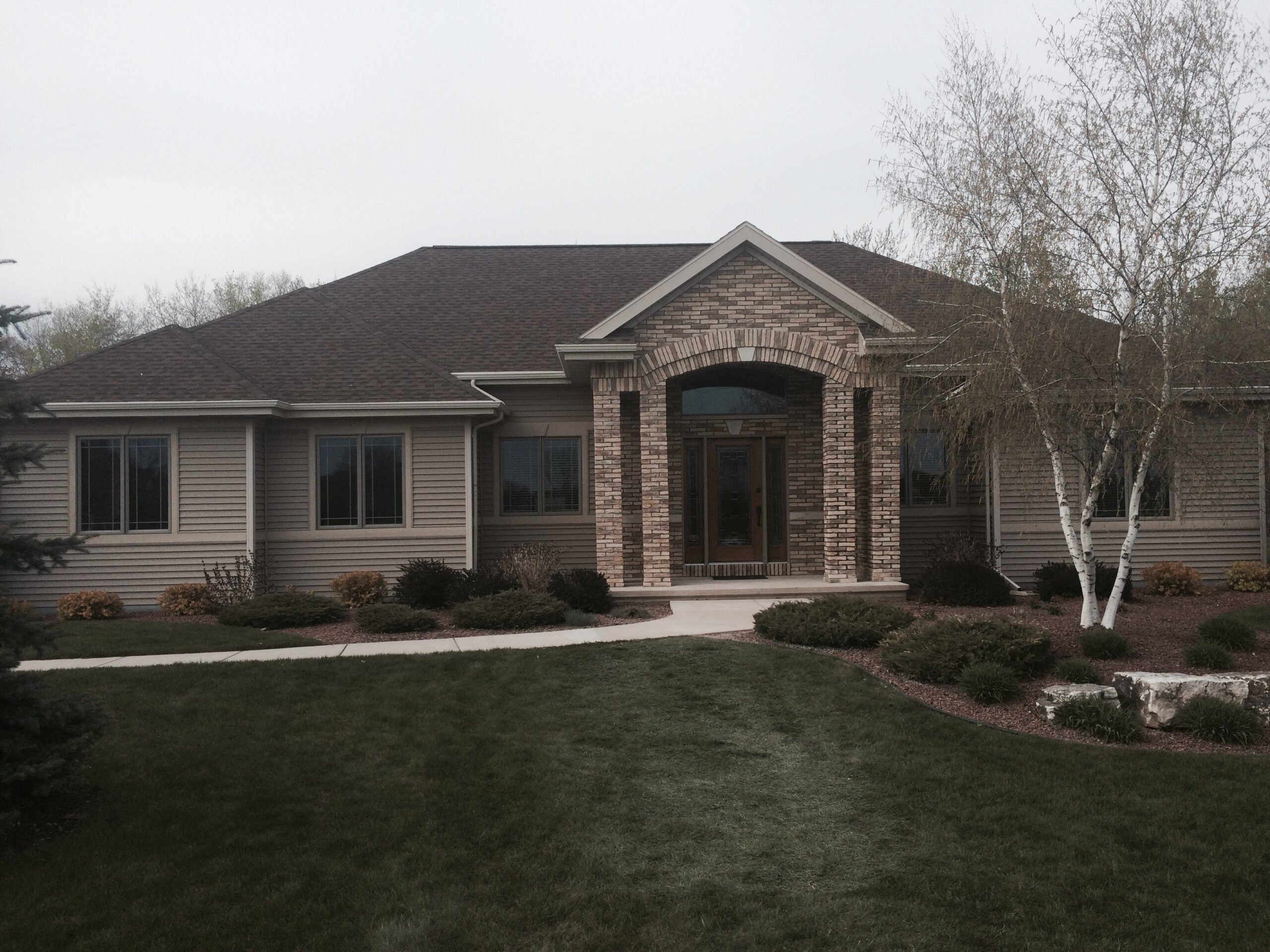 A modern suburban home with a brick entrance. 